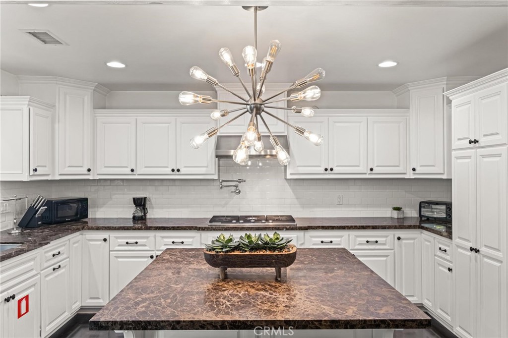 2219 Estribo Drive Rolling Hills Estates, CA 90274 - Photo 10 of 58 a kitchen with kitchen island granite countertop white cabinets and white appliances