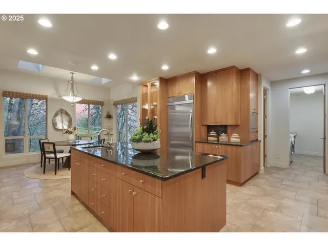 a kitchen with kitchen island granite countertop a large counter top stainless steel appliances and cabinets