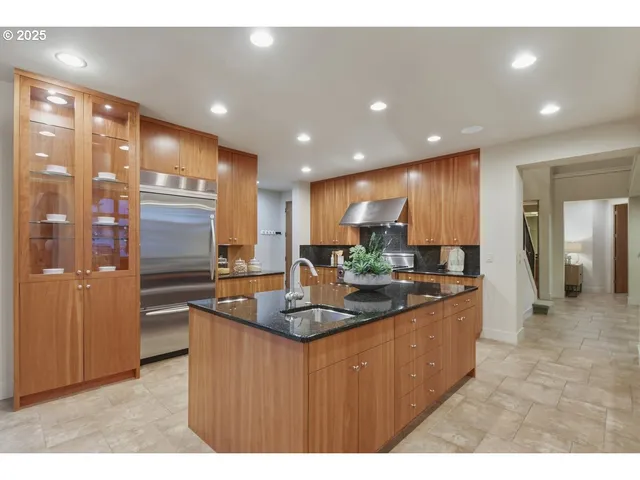 a kitchen with stainless steel appliances granite countertop a sink and a refrigerator