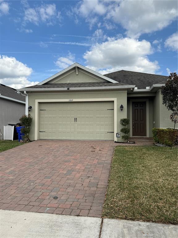 1809 Reflection Lane St. Cloud, FL 34771 - Photo 3 of 32 a front view of a house with a yard and garage