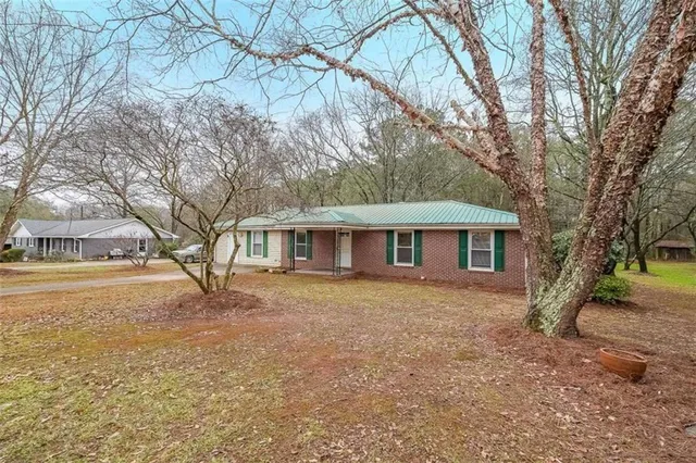a view of a yard in front of a house with a large tree