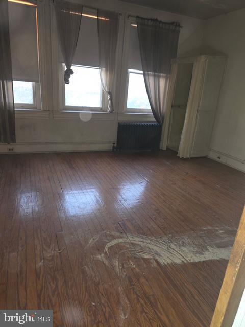 2721 North Calvert Street Baltimore, MD 21218 - Photo 24 of 29 en empty room with wooden floor and windows