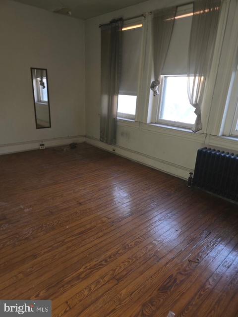 2721 North Calvert Street Baltimore, MD 21218 - Photo 27 of 29 an empty room with wooden floor and windows