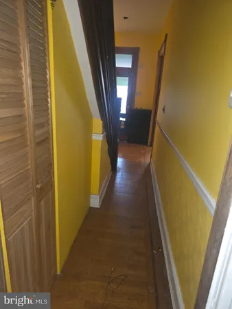 a view of a hallway with wooden floor and door