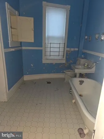 a bathroom with a tub sink and mirror