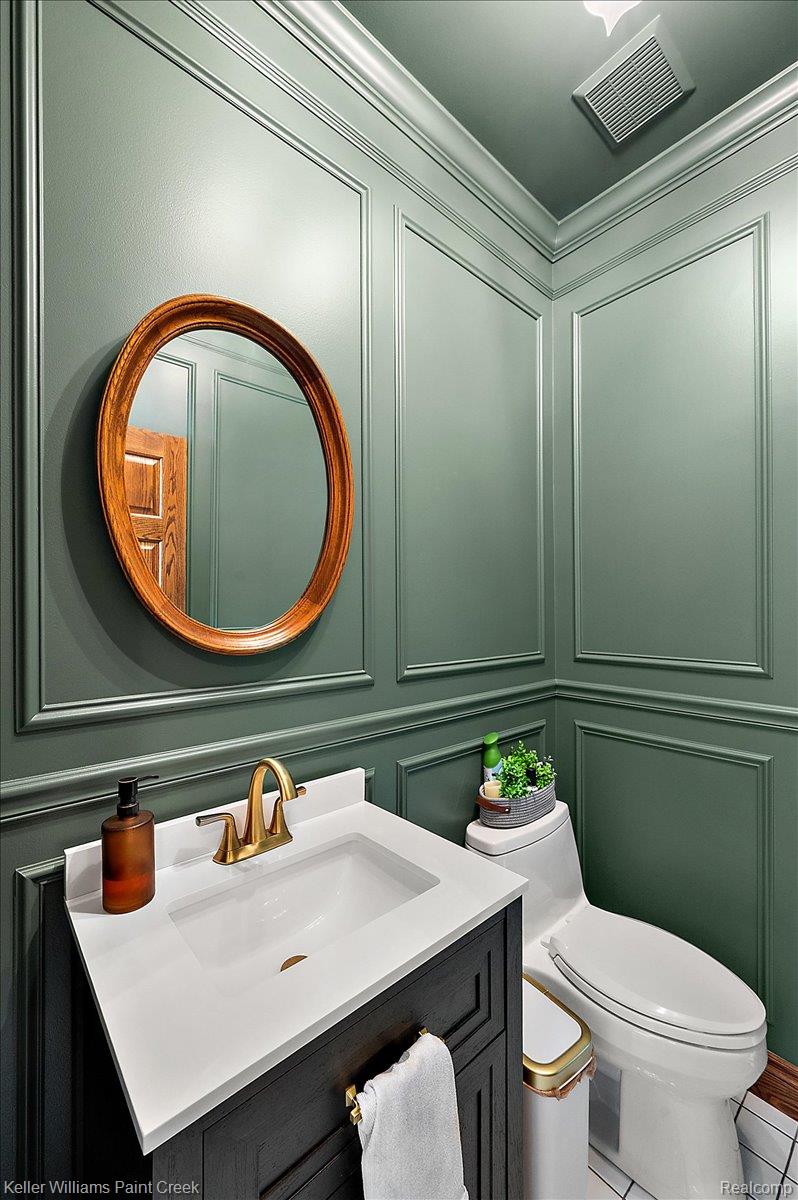 69069 Campground Road Romeo, MI 48065 - Photo 39 of 78 Powder room featuring detailed wall molding, a white vanity with a gold-toned faucet, and a round wood-framed mirror
