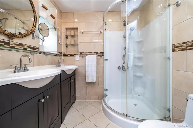 a bathroom with a sink a toilet a mirror and shower