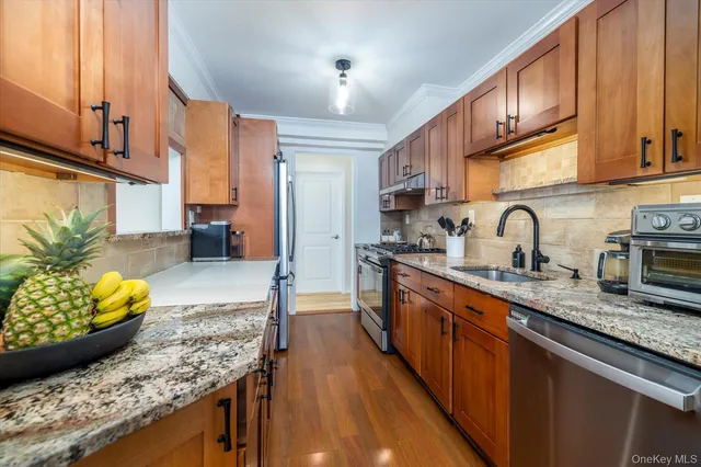 a kitchen with stainless steel appliances granite countertop a sink stove and cabinets