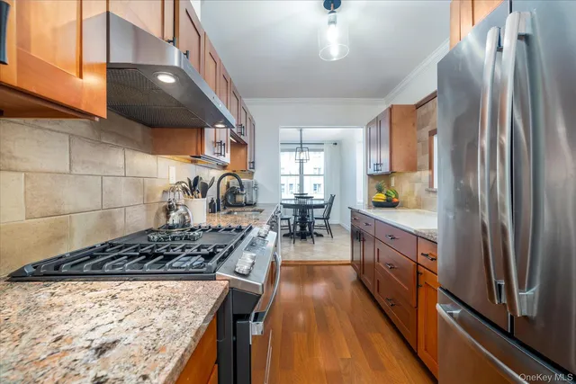 a kitchen with stainless steel appliances granite countertop a stove refrigerator and cabinets