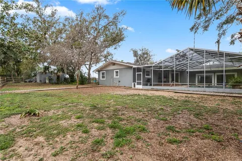 a view of a house with a backyard and a tree