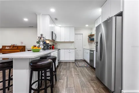 a kitchen with stainless steel appliances a refrigerator and a stove top oven