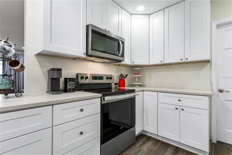 a kitchen with white cabinets and appliances