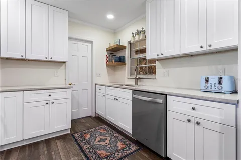 a kitchen with white cabinets and sink