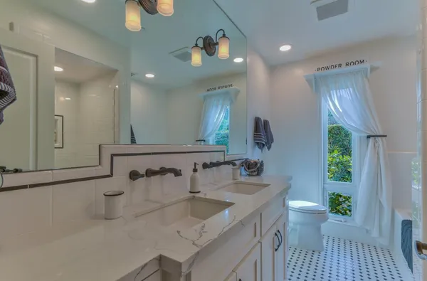 a spacious bathroom with a double vanity sink a mirror and a shower