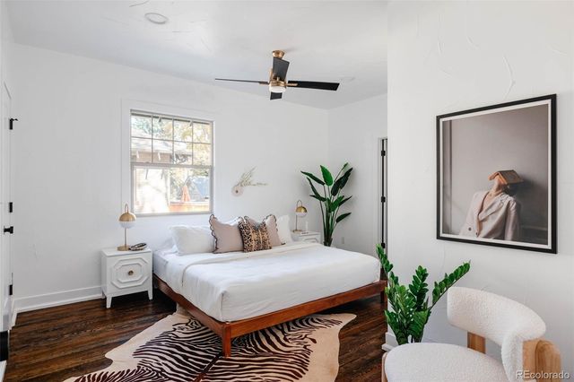 a bedroom with a large bed and a potted plant