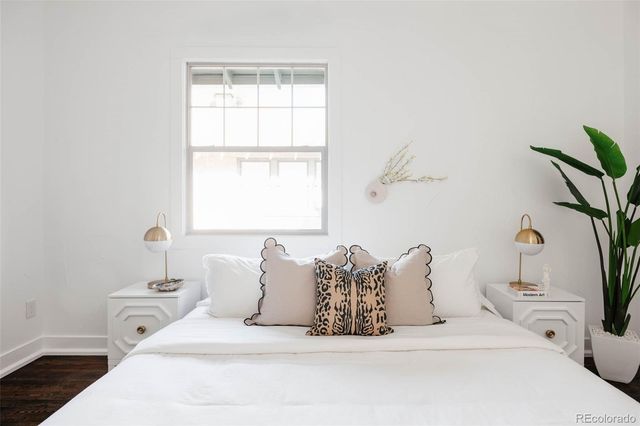 a large white bed sitting in a bathroom next to a window