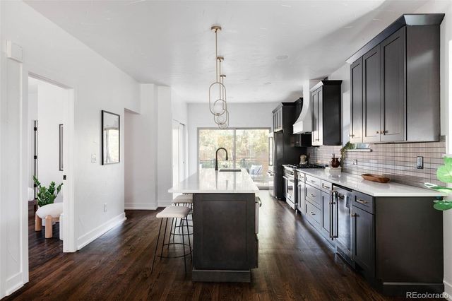 a view of a kitchen counter space a sink wooden floor and a window