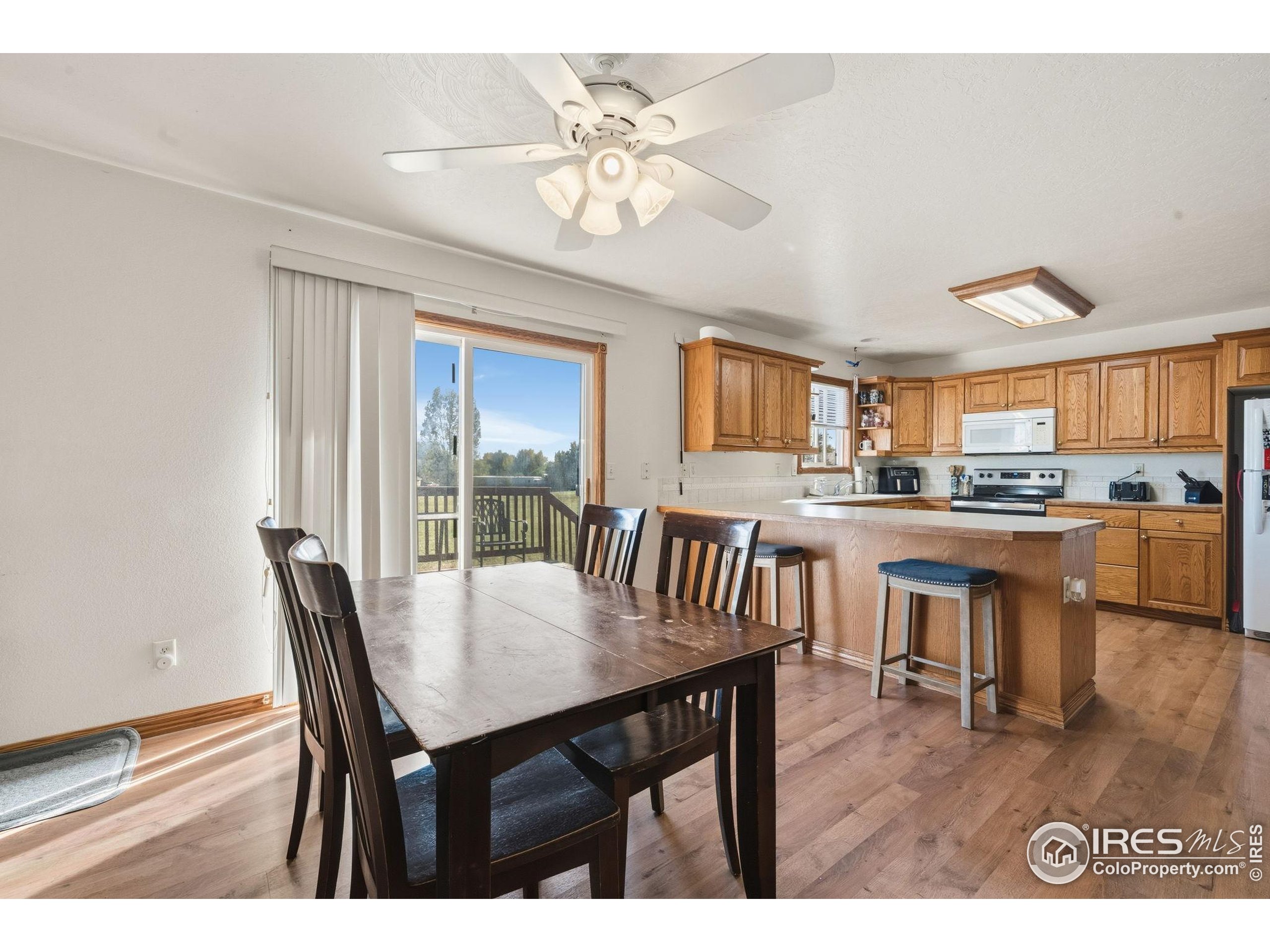 3340 35th Street Greeley, CO 80634 - Photo 5 of 10 a view of a dining room with furniture window and wooden floor