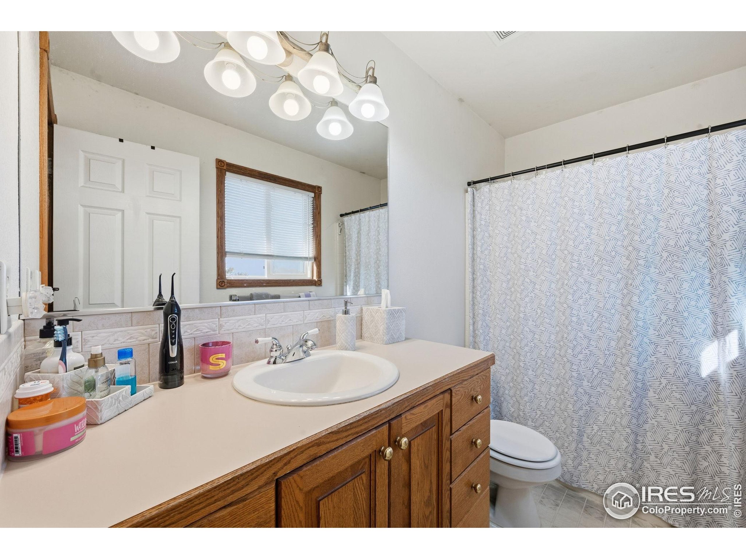 3340 35th Street Greeley, CO 80634 - Photo 10 of 10 a bathroom with a sink vanity mirror and toilet