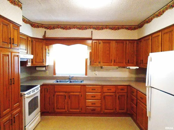 a kitchen with stainless steel appliances granite countertop a sink a stove and a refrigerator