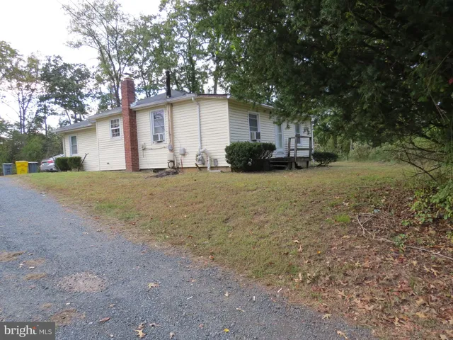 a view of a house with a yard and large tree