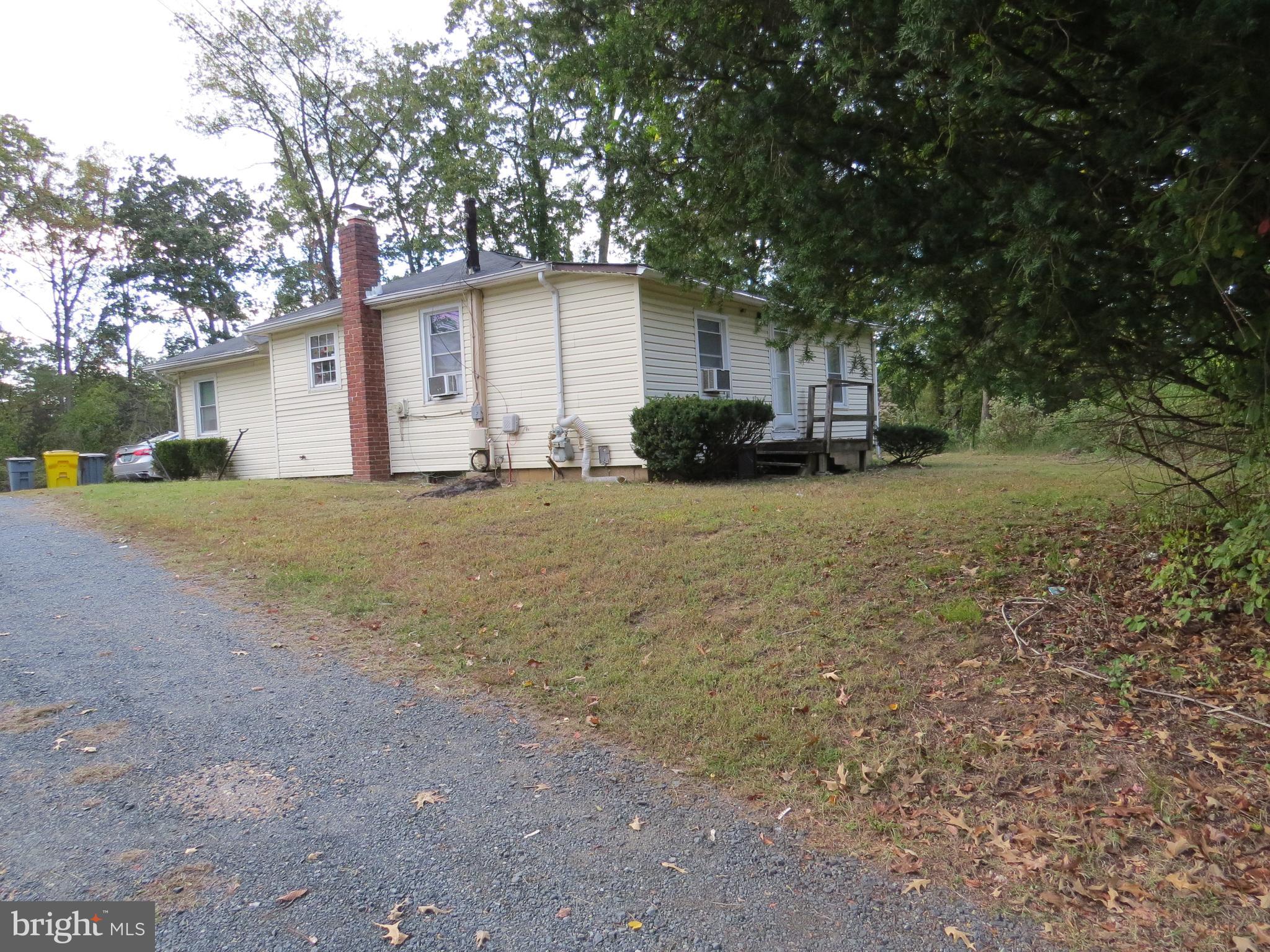 a view of a house with a yard and large tree