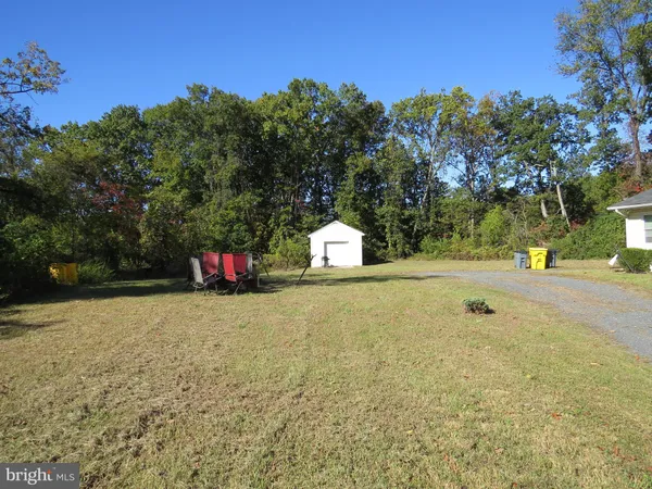 a backyard of a house with lots of green space and outdoor seating