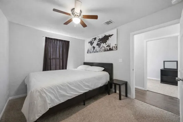 a bedroom with a large bed and a chandelier