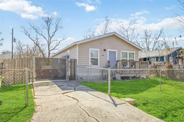 a front view of a house with a yard and trees