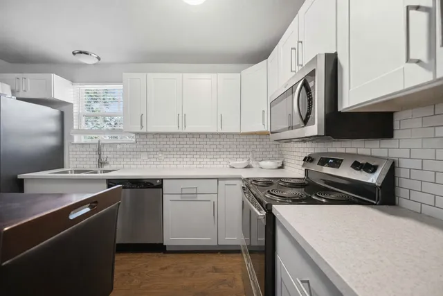 a kitchen with stainless steel appliances granite countertop a sink stove and refrigerator