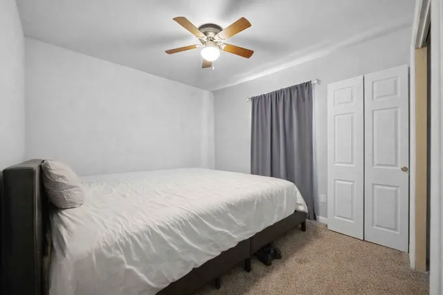 a bedroom with a bed and a ceiling fan