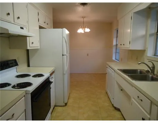 a kitchen that has a sink a stove and cabinets