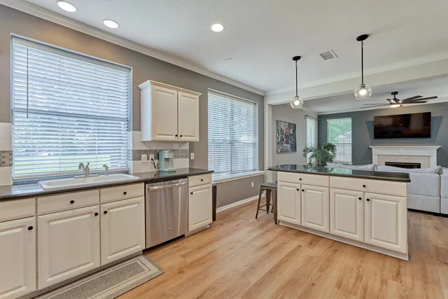 a large kitchen with cabinets a sink and dishwasher a stove with wooden floor