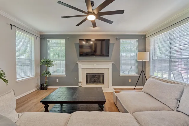 a living room with furniture a flat screen tv and a fireplace