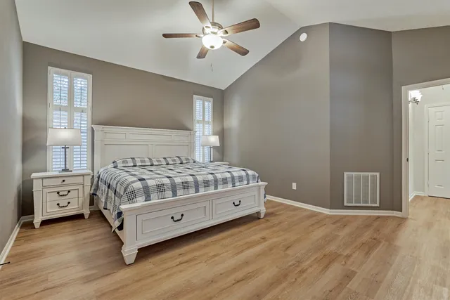 a bedroom with a large bed and a chandelier