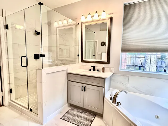 a bathroom with a tub sink and mirror
