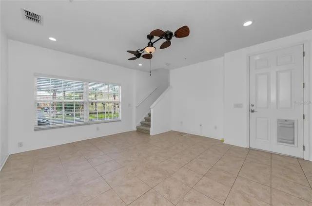 a view of a livingroom with a ceiling fan and window