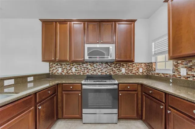a kitchen with stainless steel appliances granite countertop a refrigerator stove and microwave