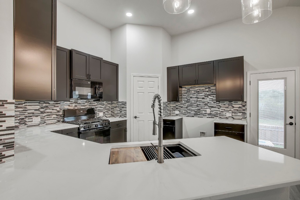 406 Dragon Ridge Road Buda, TX 78610 - Photo 11 of 39 a kitchen with a refrigerator and a stove top oven