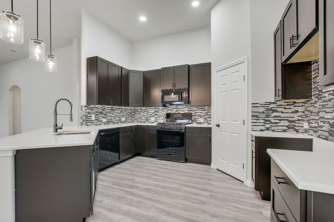 406 Dragon Ridge Road Buda, TX 78610 - Photo 14 of 39 a kitchen with stainless steel appliances kitchen island granite countertop a sink stove and refrigerator