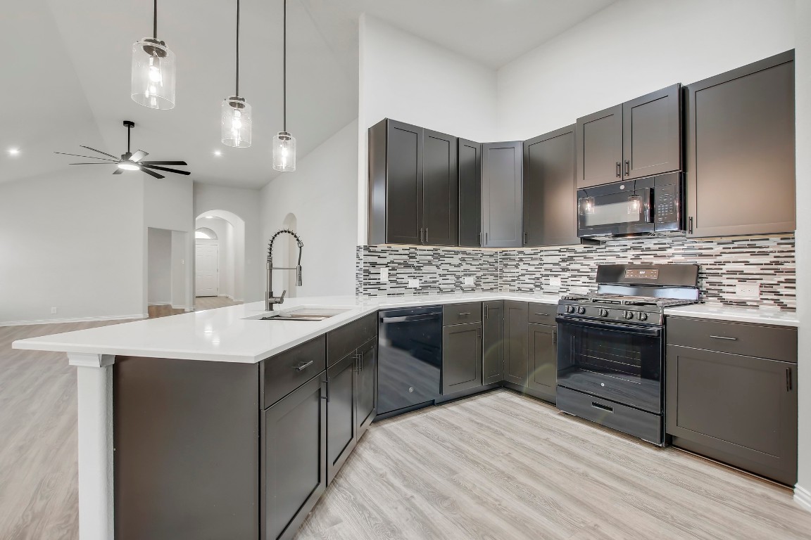406 Dragon Ridge Road Buda, TX 78610 - Photo 15 of 39 a large kitchen with a sink stove and refrigerator