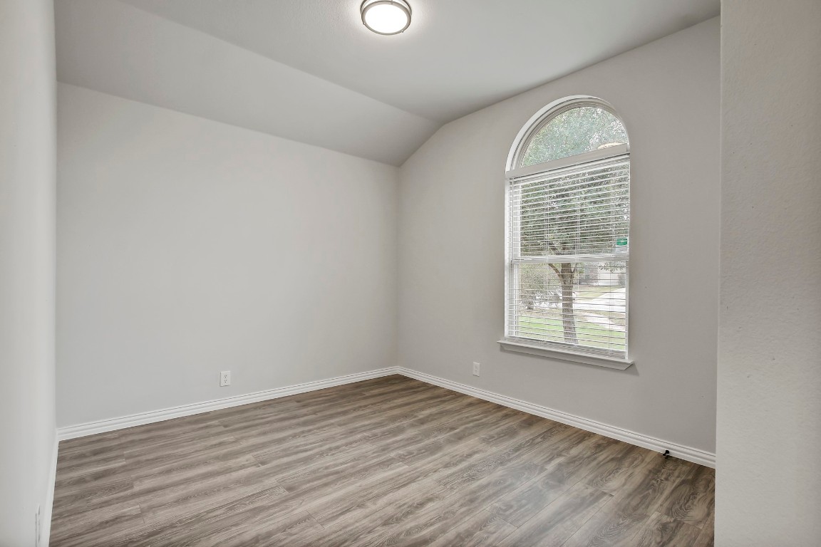 406 Dragon Ridge Road Buda, TX 78610 - Photo 27 of 39 an empty room with wooden floor and windows