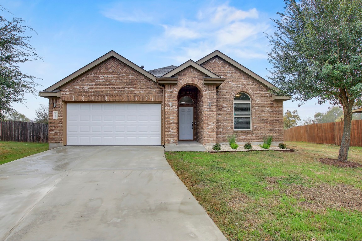 406 Dragon Ridge Road Buda, TX 78610 - Photo 3 of 39 a front view of a house with a yard and garage