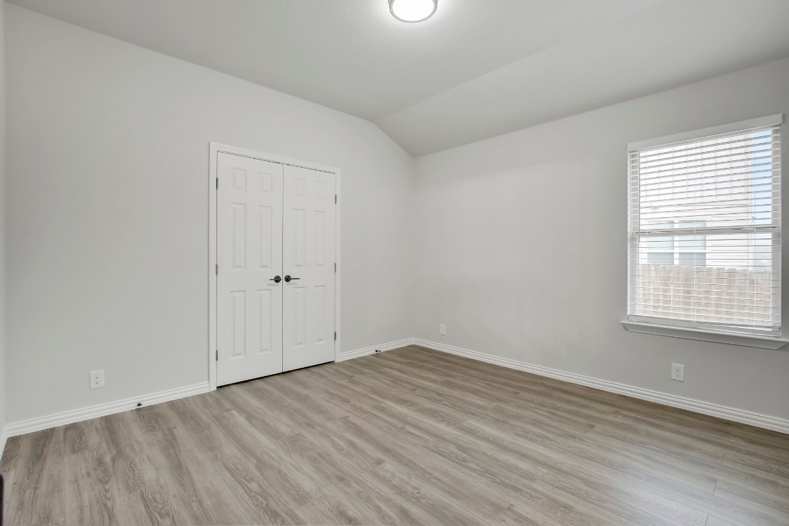 406 Dragon Ridge Road Buda, TX 78610 - Photo 31 of 39 an empty room with wooden floor and windows