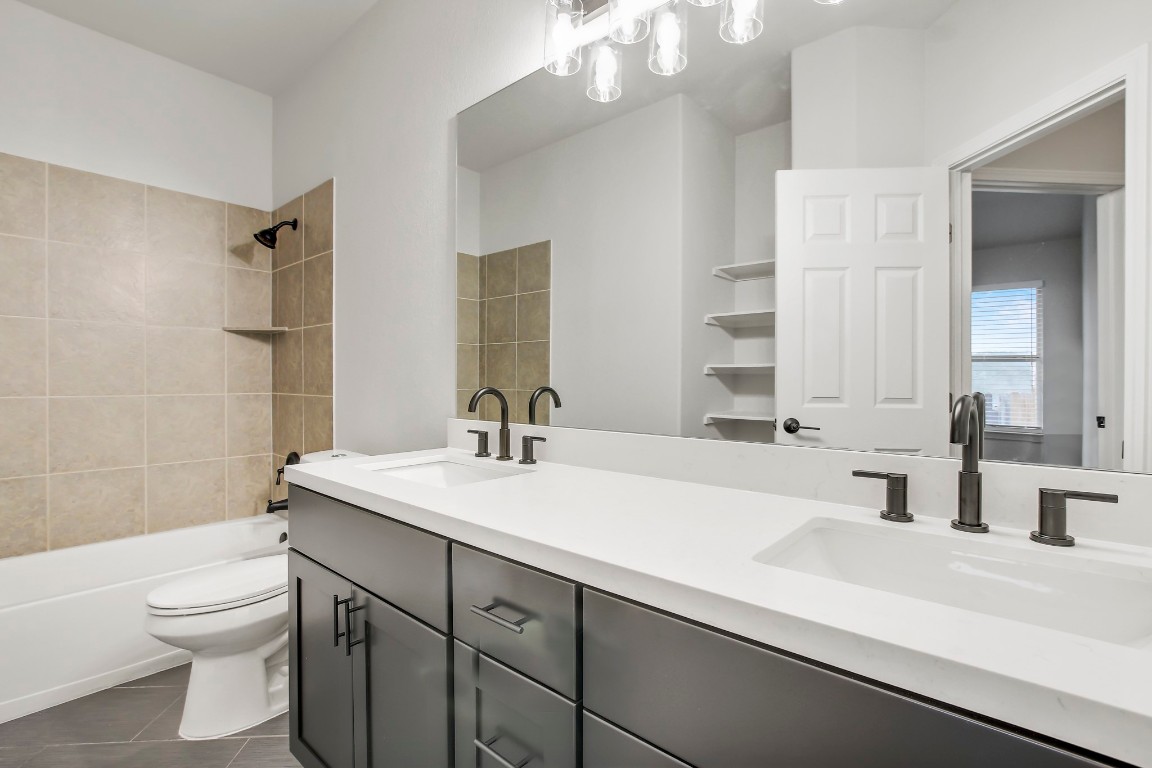 406 Dragon Ridge Road Buda, TX 78610 - Photo 33 of 39 a bathroom with a sink a toilet and shower