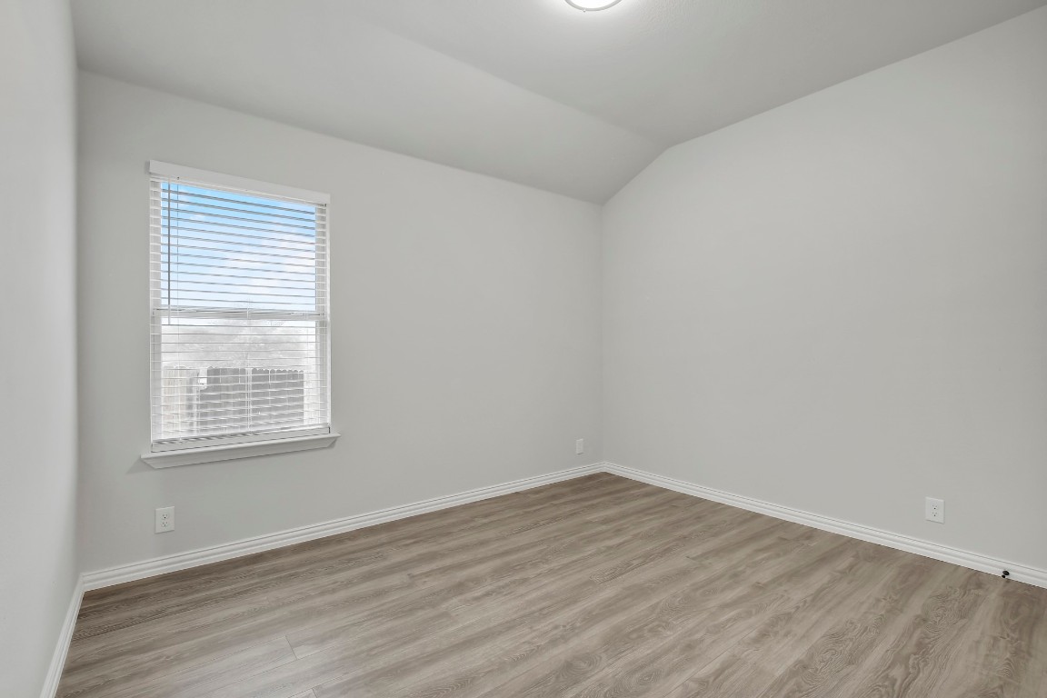 406 Dragon Ridge Road Buda, TX 78610 - Photo 35 of 39 wooden floor in an empty room with a window