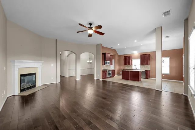 a view of a living room with wooden floor and a fireplace