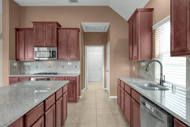 a kitchen with stainless steel appliances granite countertop a sink stove and cabinets