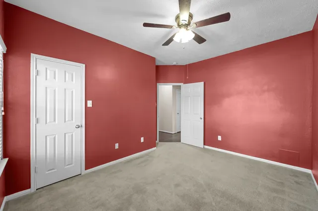 an empty room with closet and a ceiling fan