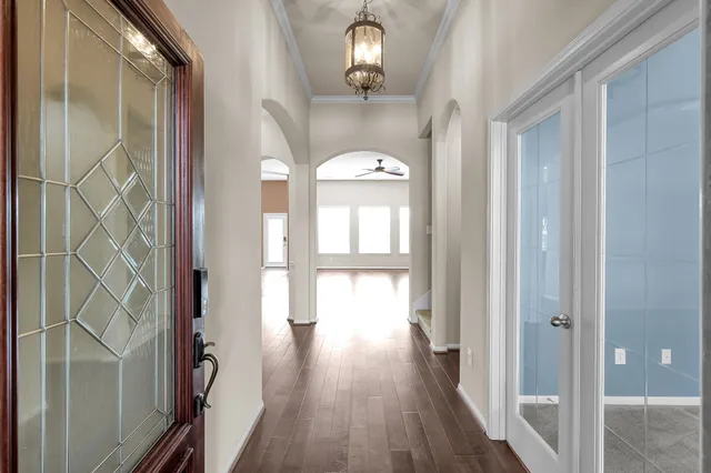 a view of a hallway with wooden floor and front door